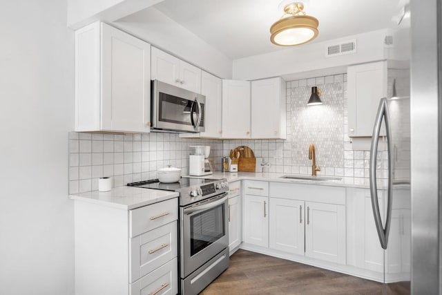 5813 Brentwood Trce, Brentwood, TN 37027 - kitchen with appliances with stainless steel finishes, backsplash, white cabinetry, and dark wood finished floors