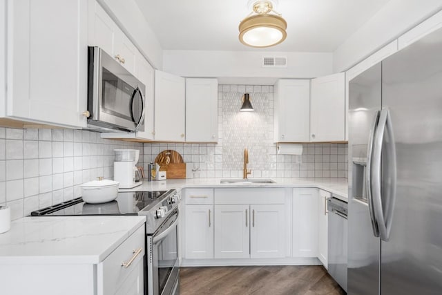 5813 Brentwood Trce, Brentwood, TN 37027 - kitchen with appliances with stainless steel finishes, backsplash, white cabinets, and dark wood finished floors