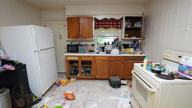 606 E Church St, Kenton, TN 38233 - kitchen with white appliances, brown cabinets, light countertops, and wood walls
