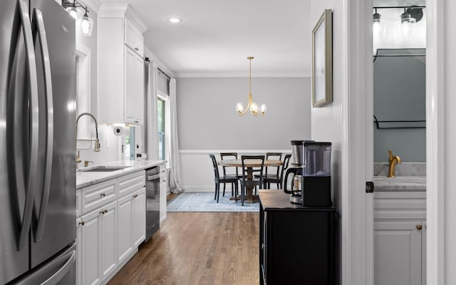 8366 Gracie Mac Ln, Ooltewah, TN 37363 - kitchen with appliances with stainless steel finishes, white cabinetry, dark wood-type flooring, a chandelier, and a wainscoted wall