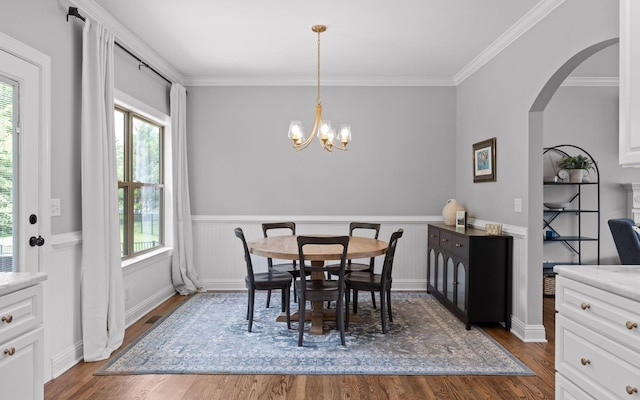 8366 Gracie Mac Ln, Ooltewah, TN 37363 - dining room featuring healthy amount of natural light, dark wood-style flooring, a chandelier, arched walkways, and crown molding
