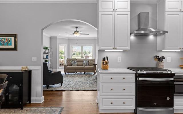 8366 Gracie Mac Ln, Ooltewah, TN 37363 - kitchen with stainless steel gas range oven, wall chimney exhaust hood, arched walkways, crown molding, and ceiling fan