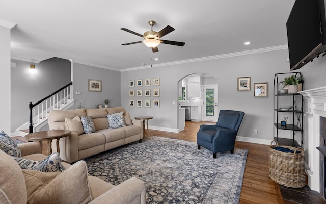 8366 Gracie Mac Ln, Ooltewah, TN 37363 - living area with arched walkways, ceiling fan, a fireplace, ornamental molding, and wood finished floors