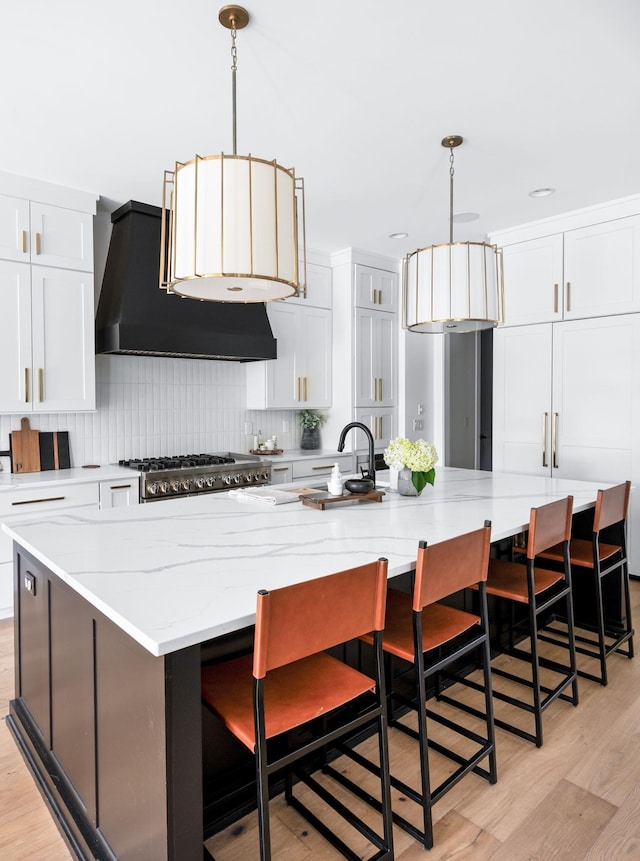 1526 Lipscomb Dr, Brentwood, TN 37027 - kitchen with exhaust hood, backsplash, a large island, light wood-style floors, and white cabinetry