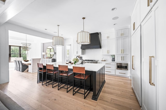 1526 Lipscomb Dr, Brentwood, TN 37027 - kitchen featuring custom exhaust hood, light wood-style floors, white cabinets, a breakfast bar, and recessed lighting