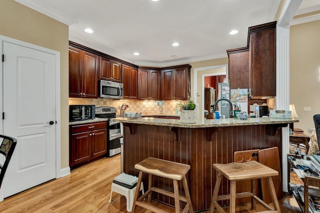 7003 Neville Dr, Ooltewah, TN 37363 - kitchen with stainless steel appliances, ornamental molding, decorative backsplash, light stone counters, and a peninsula