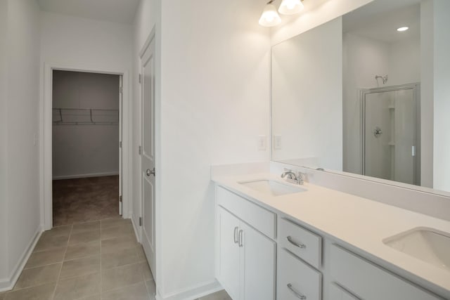 217 Summerlin Dr, Gallatin, TN 37066 - bathroom featuring double vanity, a spacious closet, a shower stall, tile patterned flooring, and recessed lighting