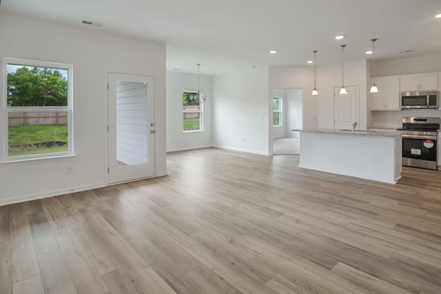 217 Summerlin Dr, Gallatin, TN 37066 - kitchen featuring stainless steel appliances, open floor plan, recessed lighting, light wood-style floors, and white cabinetry