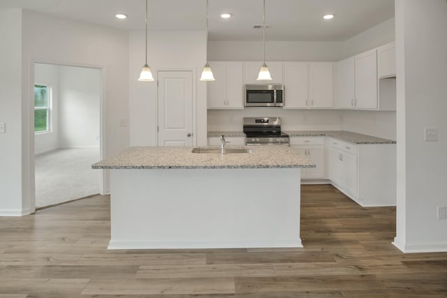 217 Summerlin Dr, Gallatin, TN 37066 - kitchen with appliances with stainless steel finishes, light stone countertops, white cabinetry, recessed lighting, and wood finished floors