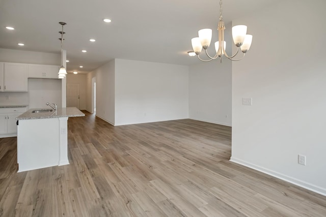 217 Summerlin Dr, Gallatin, TN 37066 - kitchen featuring recessed lighting, light wood-type flooring, light stone countertops, white cabinetry, and open floor plan