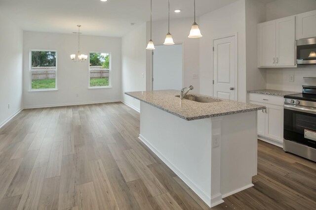 217 Summerlin Dr, Gallatin, TN 37066 - kitchen featuring stainless steel appliances, wood finished floors, light stone counters, white cabinets, and recessed lighting