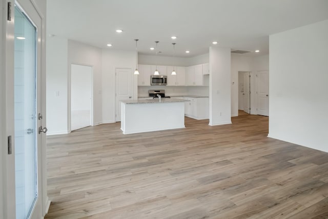 217 Summerlin Dr, Gallatin, TN 37066 - kitchen with stainless steel microwave, range with electric stovetop, light wood-style floors, white cabinets, and recessed lighting