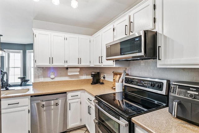 1902 Vicksburg Cir, Columbia, TN 38401 - kitchen featuring appliances with stainless steel finishes, white cabinetry, light countertops, and decorative backsplash