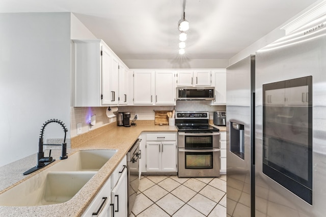 1902 Vicksburg Cir, Columbia, TN 38401 - kitchen featuring appliances with stainless steel finishes, backsplash, white cabinets, and light tile patterned flooring