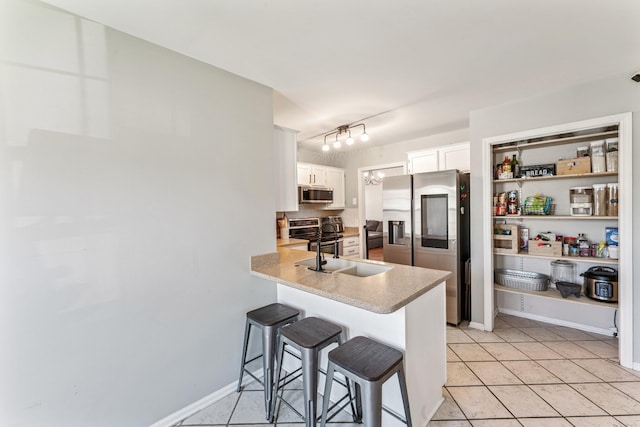 1902 Vicksburg Cir, Columbia, TN 38401 - kitchen with stainless steel appliances, a breakfast bar, white cabinets, light countertops, and a peninsula