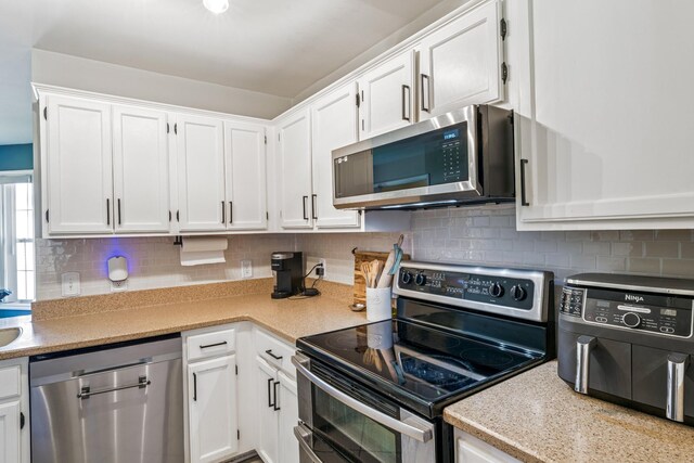 1902 Vicksburg Cir, Columbia, TN 38401 - kitchen with stainless steel appliances, white cabinetry, light countertops, and decorative backsplash