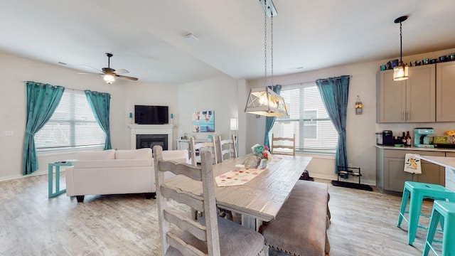 308 Whisper Wood Way, Lebanon, TN 37087 - dining room featuring light wood-style floors, ceiling fan, and a glass covered fireplace