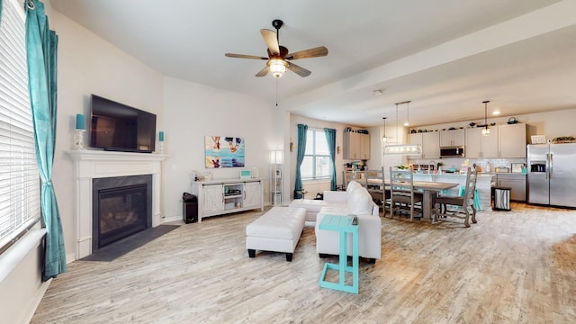 308 Whisper Wood Way, Lebanon, TN 37087 - living room with light wood-type flooring, a ceiling fan, and a fireplace with flush hearth