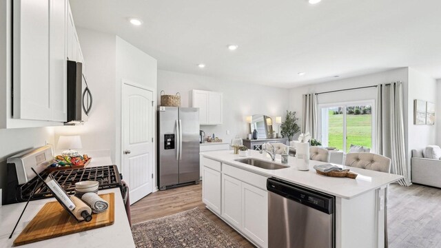 99 Hartmann Crossing Dr, Lebanon, TN 37087 - kitchen featuring stainless steel appliances, open floor plan, light wood finished floors, white cabinetry, and recessed lighting
