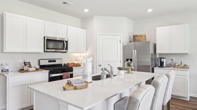 99 Hartmann Crossing Dr, Lebanon, TN 37087 - kitchen featuring stainless steel appliances, a kitchen breakfast bar, white cabinets, dark wood-style flooring, and a kitchen island with sink