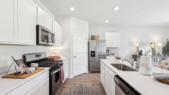99 Hartmann Crossing Dr, Lebanon, TN 37087 - kitchen with appliances with stainless steel finishes, wood finished floors, light countertops, white cabinetry, and recessed lighting