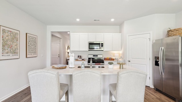 99 Hartmann Crossing Dr, Lebanon, TN 37087 - kitchen featuring stainless steel appliances, wood finished floors, white cabinetry, a breakfast bar, and recessed lighting
