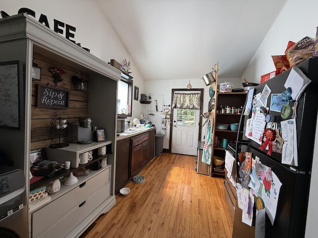 180 Webb Rd, Summertown, TN 38483 - kitchen with freestanding refrigerator, lofted ceiling, light countertops, light wood-style floors, and stacked washer / dryer