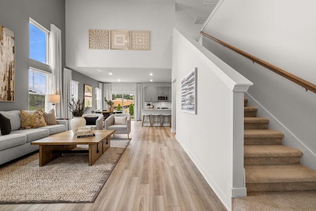 7214 Hanworth St, Fairview, TN 37062 - living room with light wood-style flooring, a high ceiling, stairs, and recessed lighting