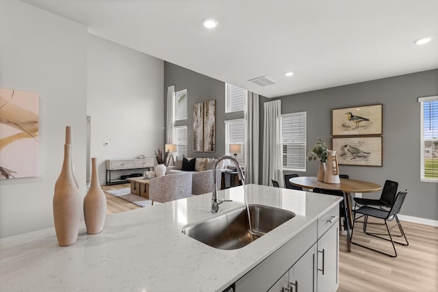 7214 Hanworth St, Fairview, TN 37062 - kitchen featuring light stone countertops, light wood-style flooring, recessed lighting, and open floor plan