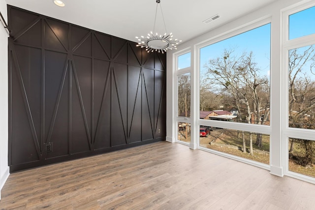 910 Youngs Ln Unit 4, Nashville, TN 37207 - empty room featuring a chandelier, light wood-type flooring, and a decorative wall