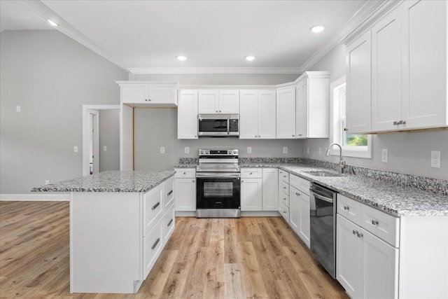 763 Potter Rd, Dickson, TN 37055 - kitchen featuring appliances with stainless steel finishes, light wood-type flooring, white cabinetry, crown molding, and a center island