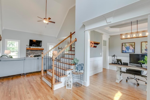 4301 Cordwood Path, Murfreesboro, TN 37127 - stairs featuring a stone fireplace, crown molding, a ceiling fan, wood finished floors, and a wainscoted wall