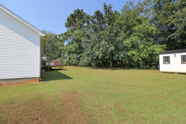 6117 Aedc Rd, Winchester, TN 37398 - view of green lawn with a wooden deck, a storage unit, and view of wooded area
