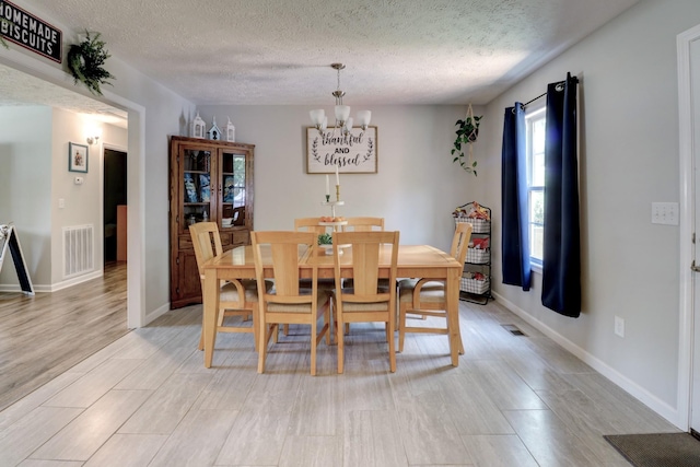 6117 Aedc Rd, Winchester, TN 37398 - dining area with a chandelier, a textured ceiling, and light wood-style floors