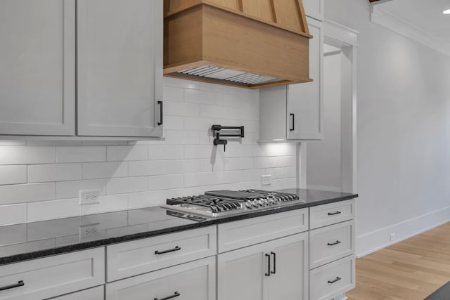 343 Circuit Rd, Franklin, TN 37064 - kitchen featuring stainless steel gas cooktop, custom exhaust hood, ornamental molding, dark stone countertops, and decorative backsplash
