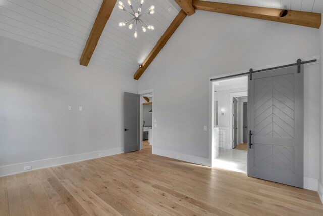 343 Circuit Rd, Franklin, TN 37064 - unfurnished living room with a chandelier, beamed ceiling, a barn door, light wood-type flooring, and high vaulted ceiling