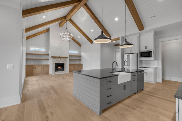 343 Circuit Rd, Franklin, TN 37064 - kitchen with stainless steel appliances, dark countertops, gray cabinets, a glass covered fireplace, and light wood-type flooring