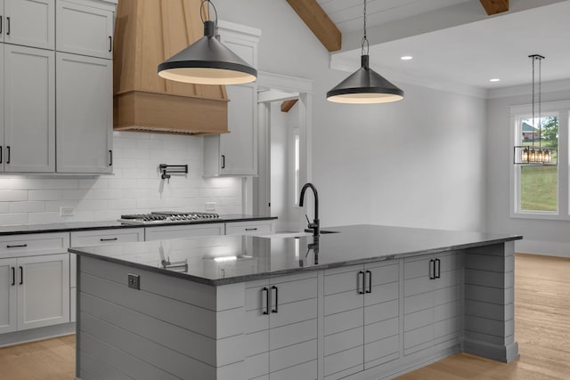343 Circuit Rd, Franklin, TN 37064 - kitchen with stainless steel gas stovetop, a kitchen island with sink, extractor fan, tasteful backsplash, and light wood-type flooring