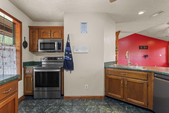 183 Jerry Smith Rd, Indian Mound, TN 37079 - kitchen featuring stainless steel appliances, brown cabinetry, a textured ceiling, ceiling fan, and dark countertops