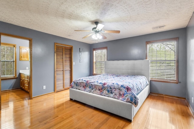 183 Jerry Smith Rd, Indian Mound, TN 37079 - bedroom with light wood-type flooring, a textured ceiling, a closet, and a ceiling fan