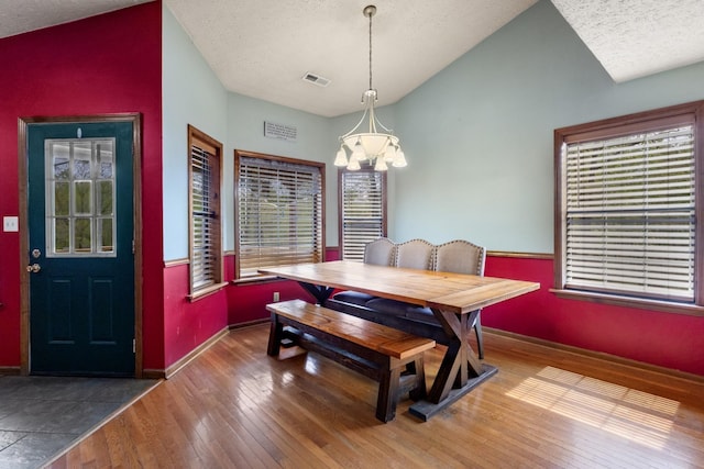 183 Jerry Smith Rd, Indian Mound, TN 37079 - dining area featuring vaulted ceiling, a chandelier, hardwood / wood-style floors, healthy amount of natural light, and a textured ceiling