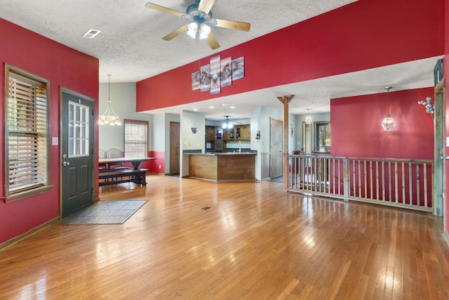 183 Jerry Smith Rd, Indian Mound, TN 37079 - living room featuring a ceiling fan, a chandelier, a textured ceiling, hardwood / wood-style floors, and lofted ceiling