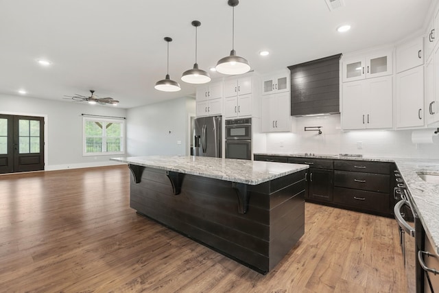 3945 Hartsville Rd, Lafayette, TN 37083 - kitchen featuring stainless steel appliances, a center island, a ceiling fan, decorative backsplash, and light wood-style floors