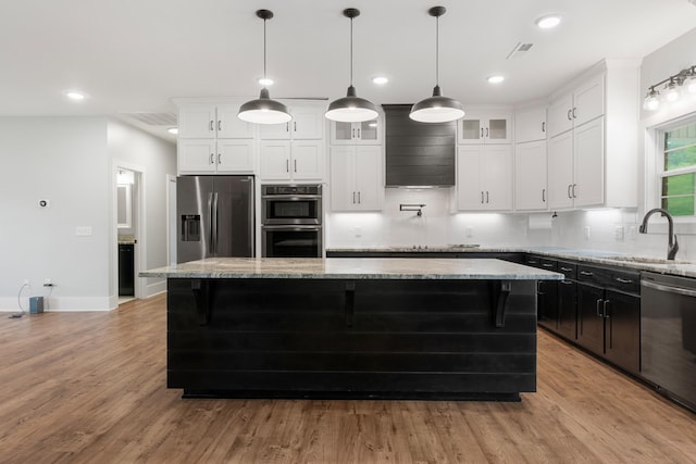 3945 Hartsville Rd, Lafayette, TN 37083 - kitchen featuring appliances with stainless steel finishes, a kitchen island, tasteful backsplash, white cabinets, and wood finished floors
