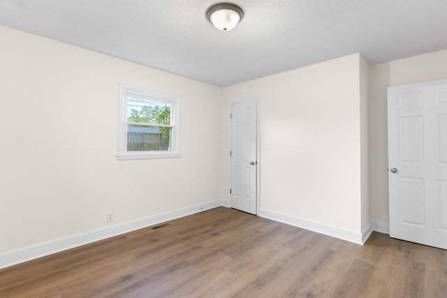 222 Jackson St, Lawrenceburg, TN 38464 - unfurnished bedroom featuring wood finished floors and a textured ceiling
