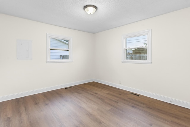 222 Jackson St, Lawrenceburg, TN 38464 - unfurnished room featuring electric panel, dark wood-style flooring, and a textured ceiling