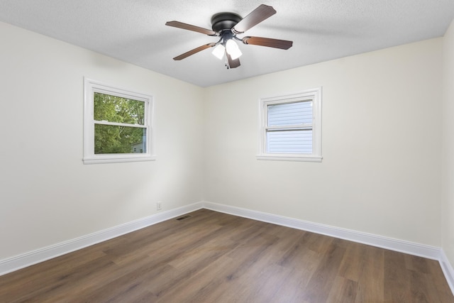 222 Jackson St, Lawrenceburg, TN 38464 - empty room with plenty of natural light, dark wood-style floors, a ceiling fan, and a textured ceiling