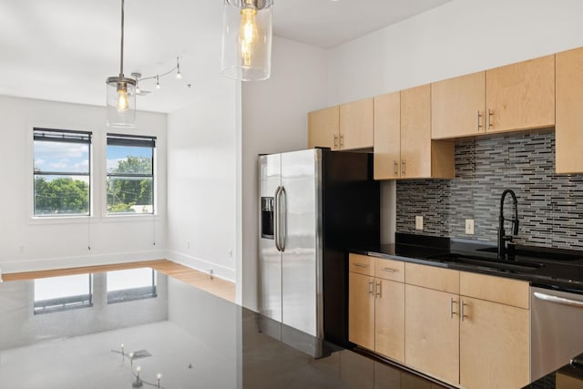 2201 8th Ave S Unit 306, Nashville, TN 37204 - kitchen with light brown cabinets, appliances with stainless steel finishes, backsplash, dark countertops, and decorative light fixtures