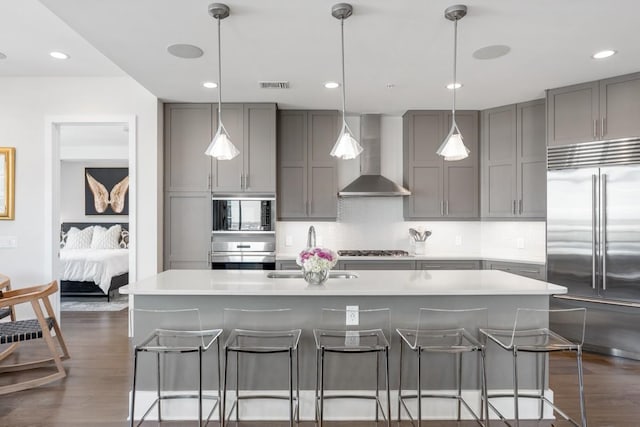 20 Rutledge St Unit 407, Nashville, TN 37210 - kitchen with built in appliances, gray cabinets, wall chimney exhaust hood, dark wood finished floors, and recessed lighting