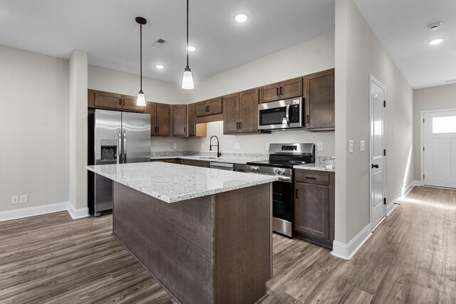 202 W Fallow Ct, Clarksville, TN 37040 - kitchen with appliances with stainless steel finishes, wood finished floors, dark brown cabinetry, a center island, and recessed lighting